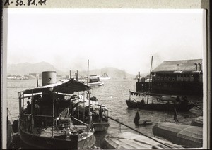 Hong Kong harbour. On the right the ferry-boat to Kowloon. In the background warships and between them, in the distance, the 'Saarbrücken' as it draws away