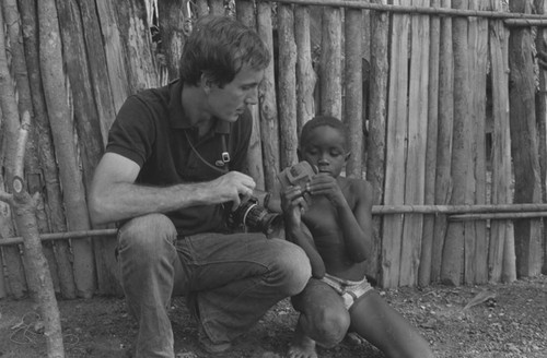 Richard Cross and a boy examining a toy camera, San Basilio de Palenque, 1977