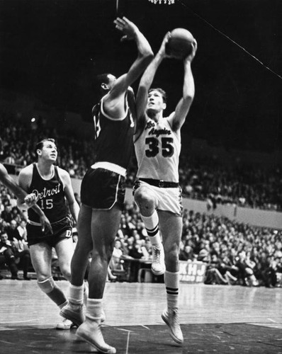 Lakers' Rudy LaRusso drives past Detroit's Jack Moreland and Reggie Harding to score