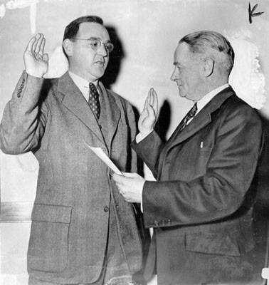 [Edmund G. Brown being sworn in as G. G. bridge director by Chief Clerk Robert Munson]