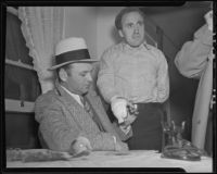 Detective Lieutenant Frank Harper examine's Lyndon "Red" Foster's injured hand, Los Angeles, 1935