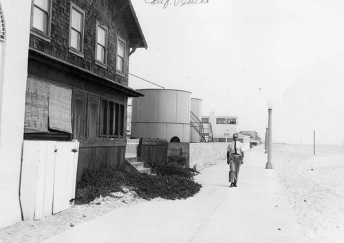Man walking past houses, east end of Venice