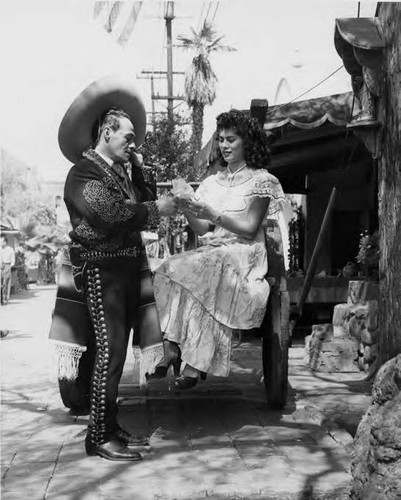 Mr. Santana handing a paper flower to Margarita Garcia both in Mexico costume