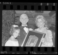 Aaron and Tori Spelling with Les Dames de Champagne president, Toni Webb posing with Host of Year award in Los Angeles, Calif., 1985