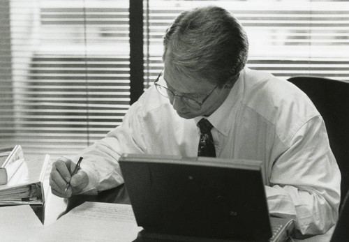 Photograph of a male teacher working at his desk