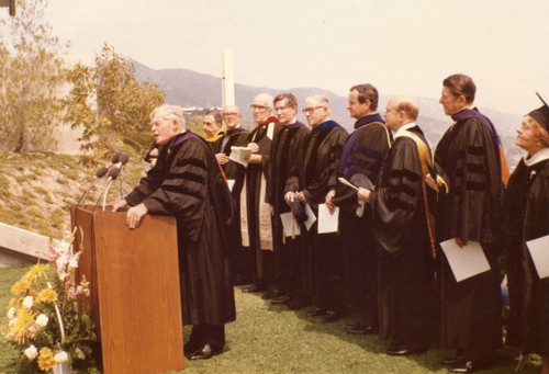 Fritz Huntsinger at the podium. L to R: Unknown, Executive Vice President White, Unknown, Vice Chancellor Runnels, Unknown, Richard Seaver, Chancellor Young, Governor Reagan, Mrs. Seaver