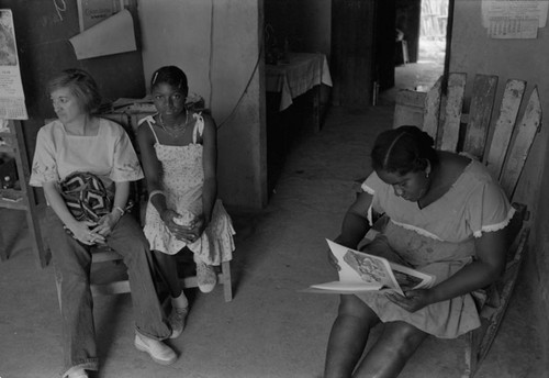 Nina S. de Friedemann and a woman looking at pictures, San Basilio del Palenque, ca. 1978