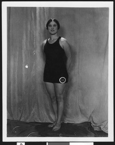 Portrait of a female swimmer wearing a letter "H" on her suit, ca.1930