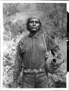 Lingela, a Havasupai Indian man, going for water with an "olla" under his arm, ca.1900