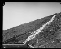 Water rushes down the hillside along a dynamited section of the Los Angeles Aqueduct in No-Name Canyon, Inyo County vicinity, [circa 1927]
