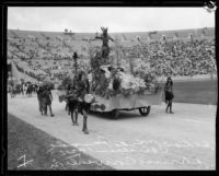 Belmont High School students in costume with float depicting California history, Shriners' parade, Los Angeles Memorial Coliseum, Los Angeles, 1925