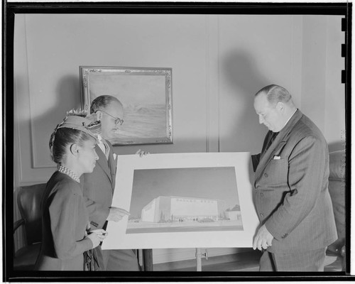 [Barker Bros. store]. Sara Little with Earl Barker and Ken Pelton looking at architect's rendering of a new Barker Bros. store