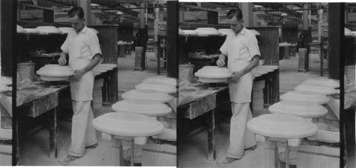 Operator attaching the "foot" to platter by wetting it with water mixed with "slip" (china body in liquid form.) "Lenox, Inc." makers of fine china ware, Trenton, N.J