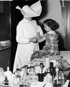 Sister Esther attends to a little girl, Jackie Barnes, 1950