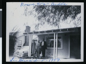 Two men and a woman posing in front of a house in San Bernardino, ca.1959