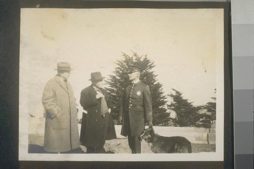 [Policeman, two men and a dog]