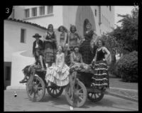 Dancers in the Old Spanish Days Fiesta seated on an old wagon at the courthouse, Santa Barbara, 1930