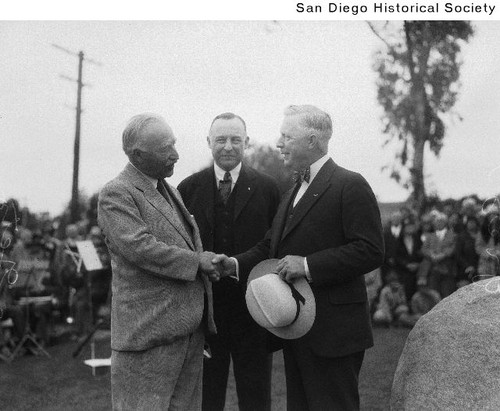 Tommy Getz shaking hands with San Diego Mayor Harry Clark as Albert V. Mayrhofer looks on