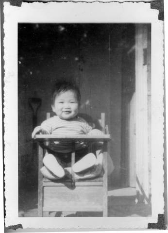 Arthur Sato, eight months, seated in baby chair at Granada Relocation Center