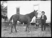 Man with horse, likely a livery stable