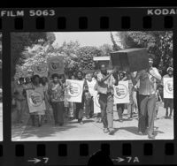 Citizens Action League members carrying signs and mock coffin up street in Pacific Palisades, Calif., 1981