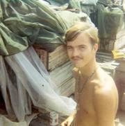Photograph of Gustafsson Standing Next To Boxes of Supplies