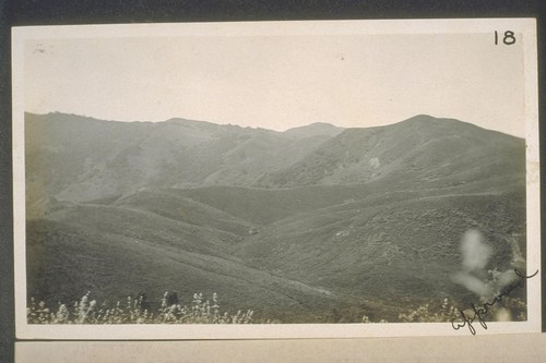 View from location of the old oil well number one, and is looking toward the south.The immediate foreground is underlain by vaqueros shales in the trough of the syncline that passes through this point. The lefthand background shows the west end of Red Mountain anticline