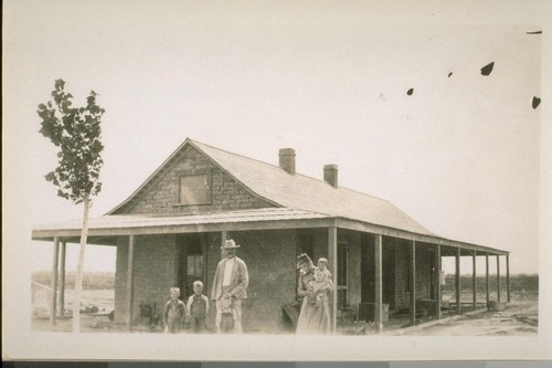 Pete Hoverly and family and their new adobe house, being the first one built in Brawley