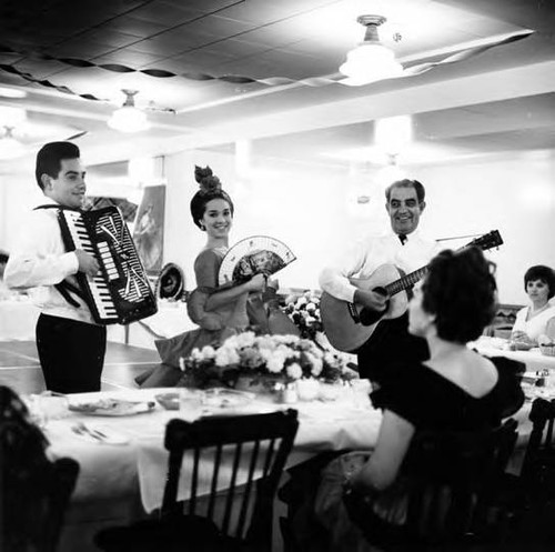 Woman at table being entertained by musicians at the 185th Birthday of Los Angeles