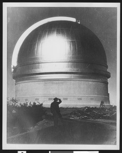 Silhouette of a man in front of the dome of an observatory, ca.1920-1930