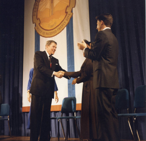 President Reagan shaking hands with the people on the stage