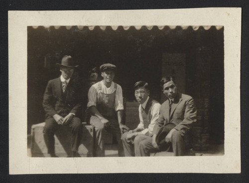 Men sitting in front of Tozai Co. store