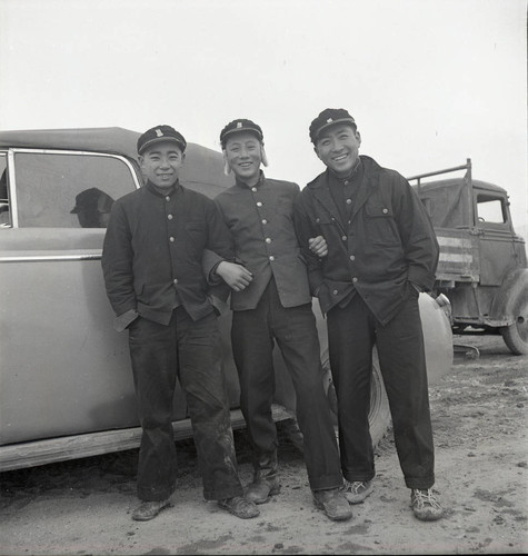 Three South Korean students posing by car