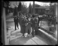 Kidnapping victim Mary Skeele walking blindfolded with a group of men [police detectives?], Los Angeles, 1933