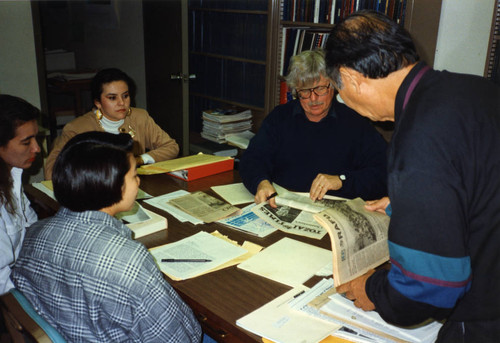 [Arthur A. Hansen, former incarceree, and students viewing Rafu Shimpo and Tozai Times newspapers]