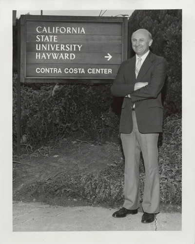 Photograph of man standing next to sign for Contra Costa Center