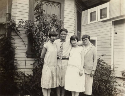 Photo of (from left to right) Dorothy Siu, her brother, friend of Dorothy and Jake's mother standing outside of a house