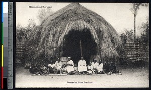 Men sitting in front of a large thatched hut, Algeria, ca.1900-1930