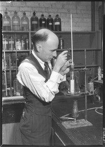 Chemist measuring the temperature of the contents of a beaker