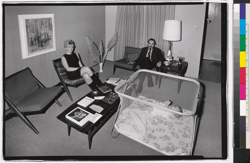 [Couple seated in living room with baby in crib, Richmond, California.]