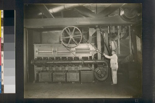 [Factory worker operating machinery.]