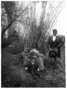 Paiute Indian family before a clump of tall reeds, ca.1900