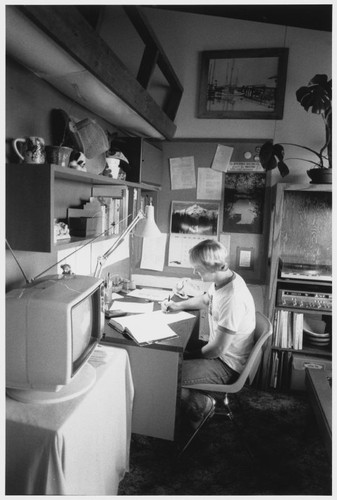 Student studying in dorm room, ca. 1980