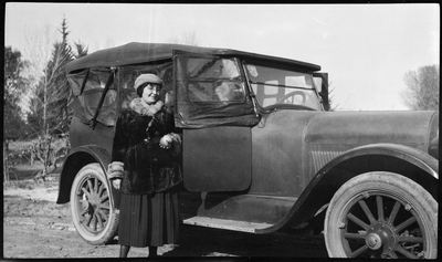 Pearl Hinds Roberts standing next to automobile