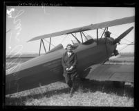 Pilot Jean Allen standing next to bi-plane in Los Angeles, Calif., circa 1930