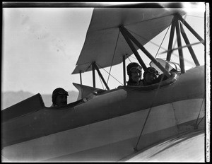 Three aviators in the cockpit of an airplane