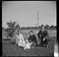 Gertrude Teel, Hattie Cline, John Teel and baby Ambrose Cline sit in the grass at John Teel's ranch, Los Angeles, [about 1915]