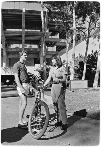 Campus police officer checking bicycles in front of Geisel Library