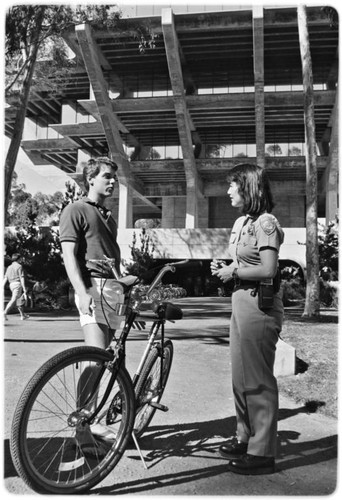 Campus police officer checking bicycles in front of Geisel Library