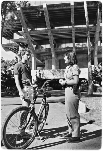 Campus police officer checking bicycles in front of Geisel Library